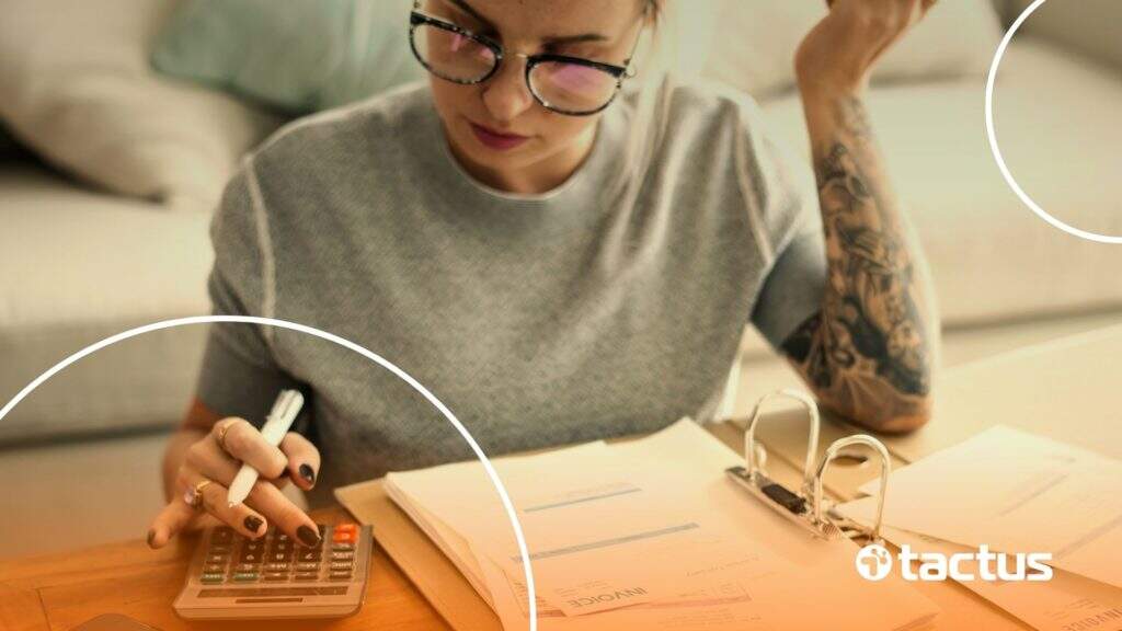 Imagem mostra mulher jovem com calculadora, simbolizando como declarar rendimentos da Hotmart no imposto de renda