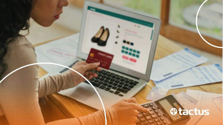 Imagem mostra mtulher jovem de perfil com cartão de crédito e calculadora, com o notebbok aberto em um e-commerce, para simbolizar como funciona o simples nacional para e-commerce